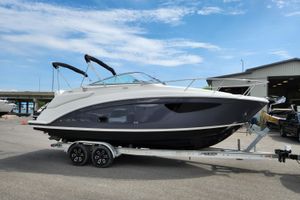 Regal 26 Express 2024 Regal 26 Express boat on trailer, parked outdoors under a clear blue sky.
