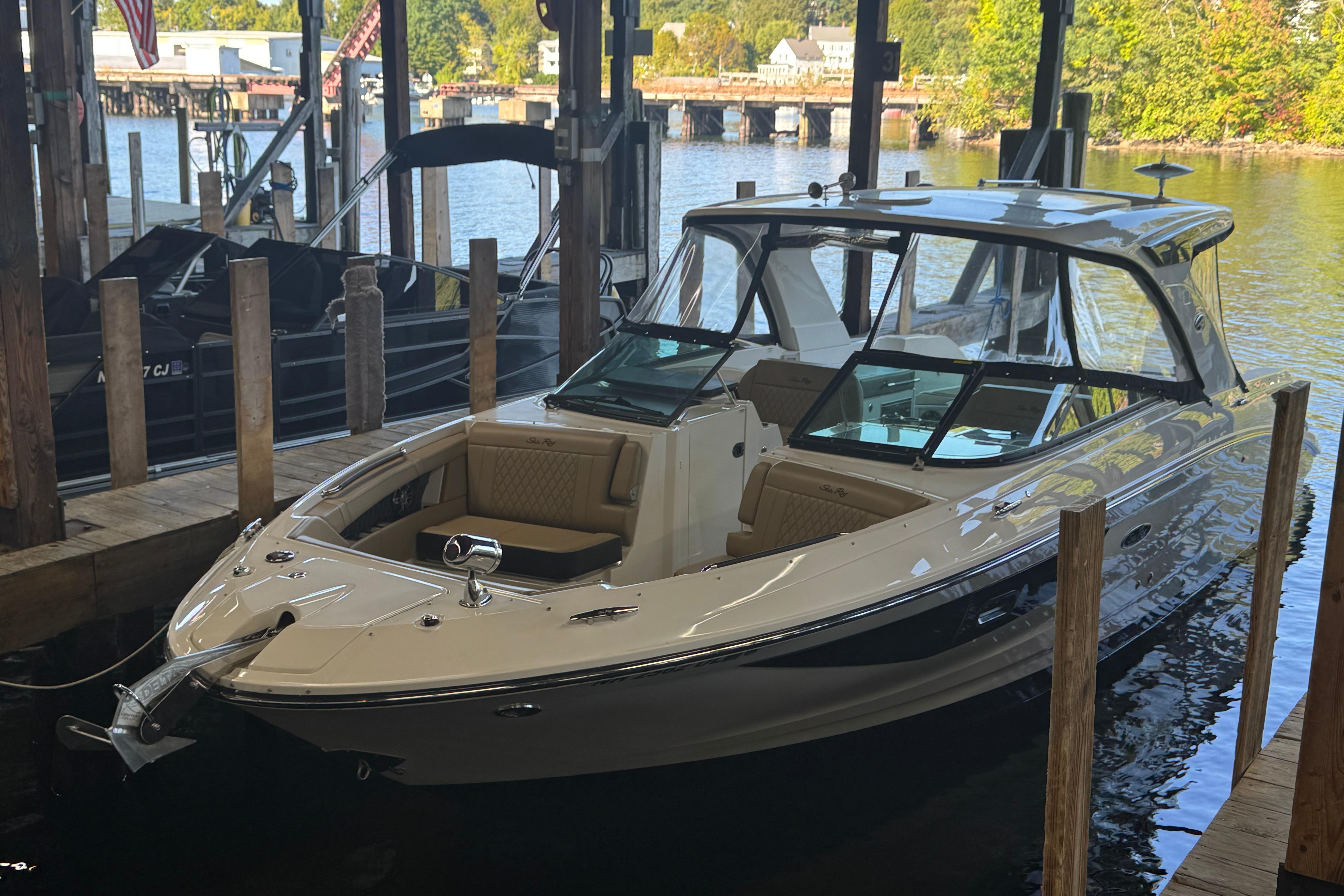 Sea Ray SLX 350 2020 Sea Ray SLX 350 boat docked in a marina, surrounded by water and wooden posts.