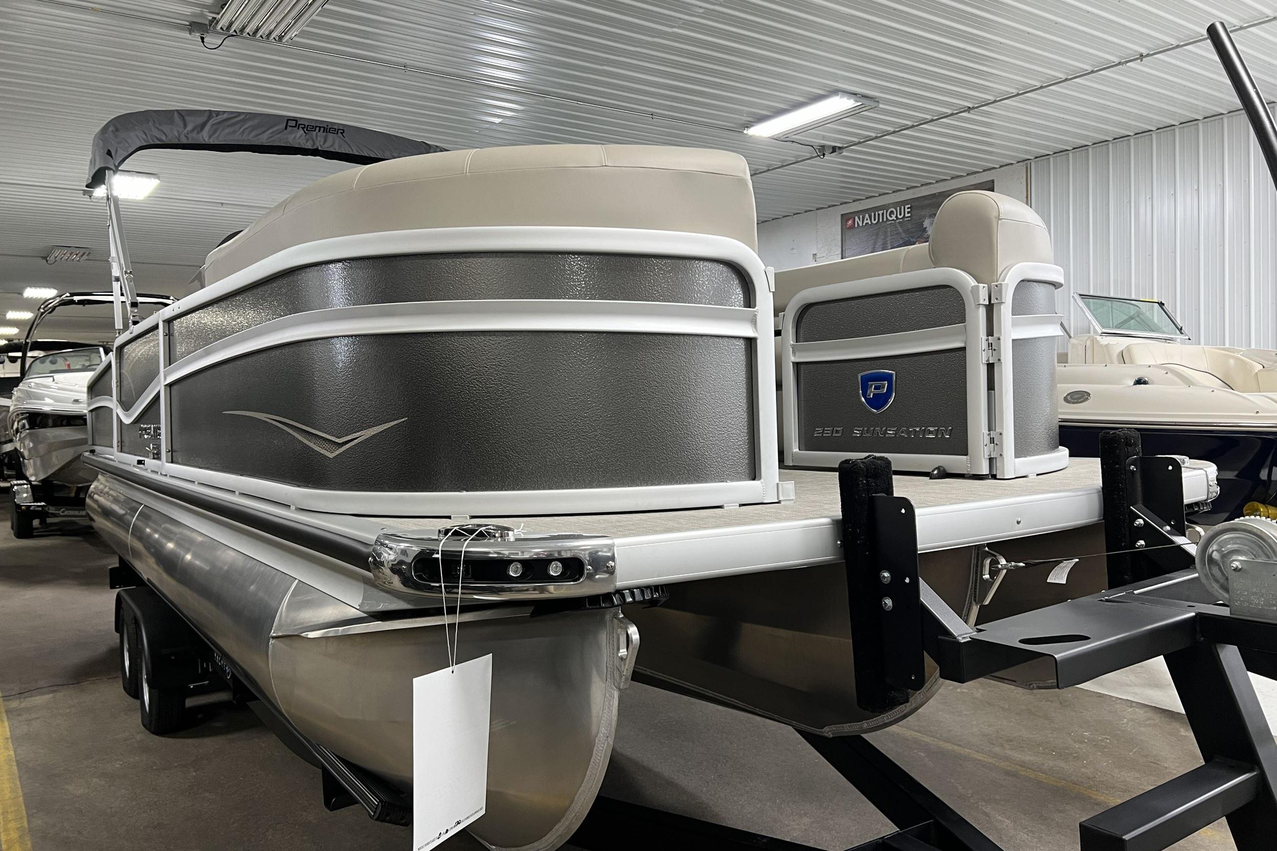 Premier Sunsation Angler 230 2023 Premier Sunsation Angler 230 pontoon boat in showroom, side view.