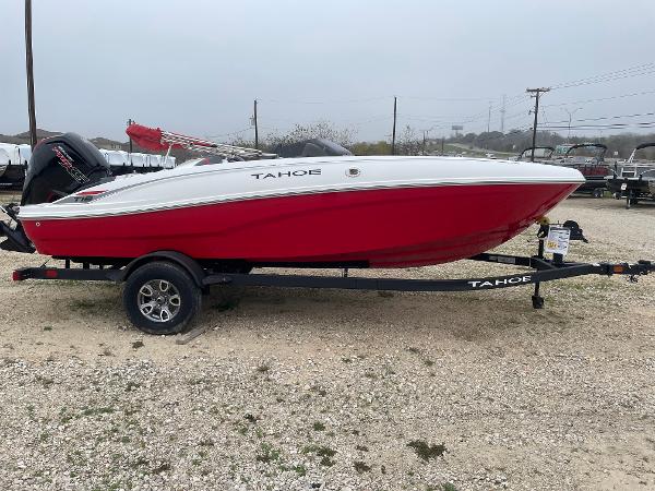 Tahoe T18 2025 Tahoe T18 boat in red and white on a trailer, parked outdoors.