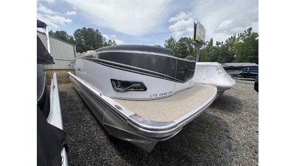 Tahoe Pontoon LTZ Cruise Rear Bench 2025 Tahoe Pontoon LTZ Cruise Rear Bench, sleek design, parked outdoors on gravel.