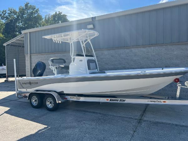 NauticStar 224 Bay 2025 NauticStar 224 Bay boat on trailer, parked outdoors near a building.
