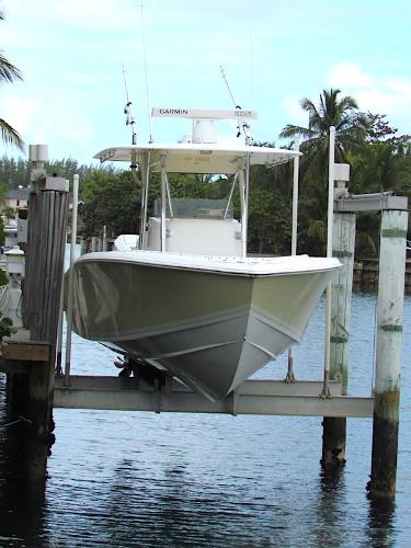 Venture 34 Open 2005 Venture 34 Open boat on lift, surrounded by water and palm trees.