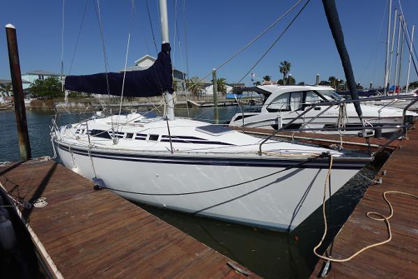 Hunter 310 1987 Hunter 310 sailboat docked at marina under clear blue sky.