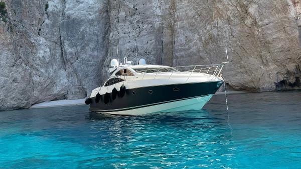 Sunseeker Predator 72 Luxury Sunseeker Predator 72 yacht from 2009 in clear blue waters near rocky cliffs.