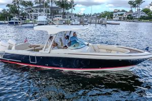 Chris-Craft Calypso 30 2019 Chris-Craft Calypso 30 boat cruising on a scenic waterfront with passengers onboard.