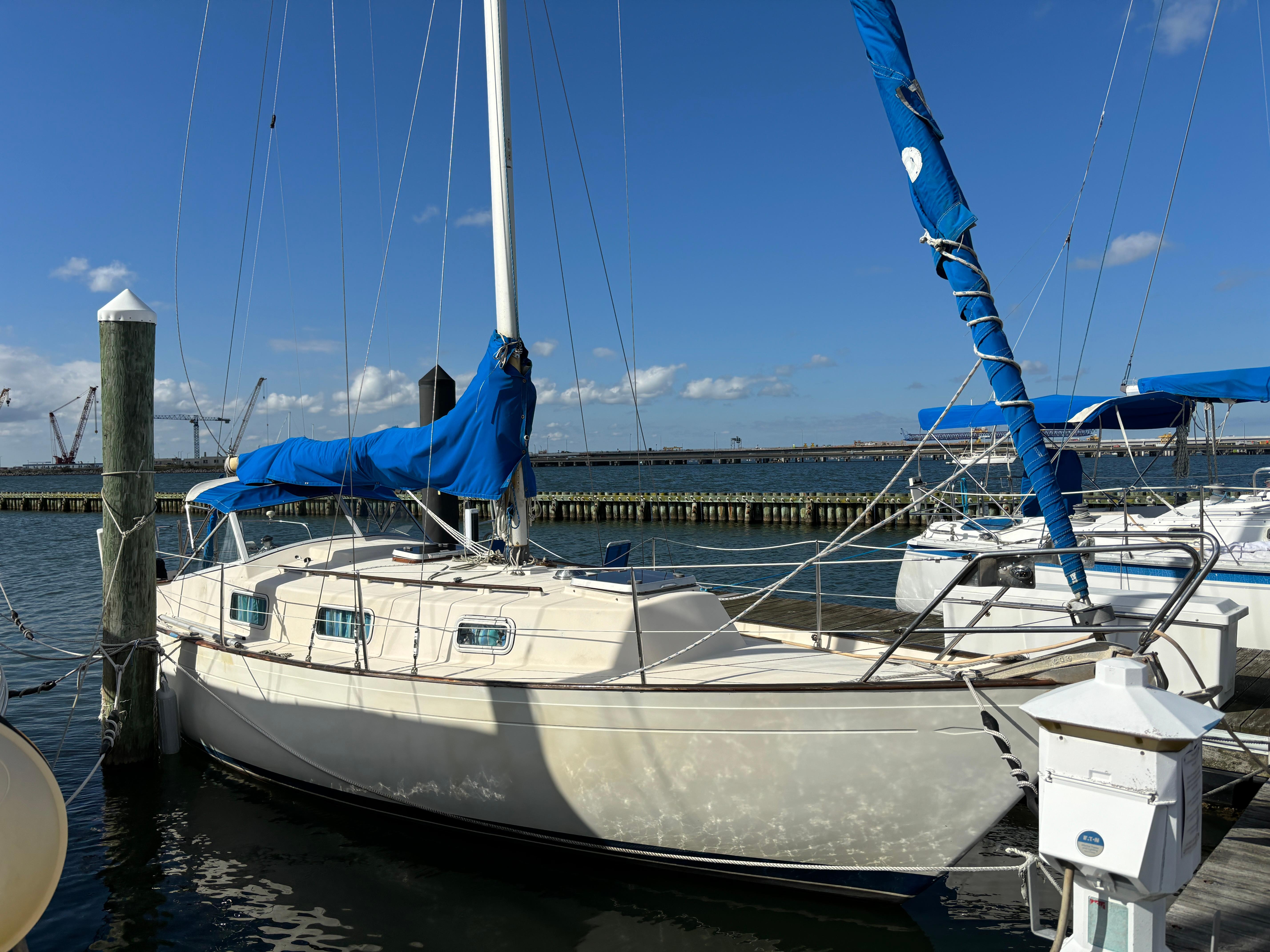 Hallberg-Rassy Monsun 31 1976 Hallberg-Rassy Monsun 31 sailboat docked with blue covers, clear sky background.
