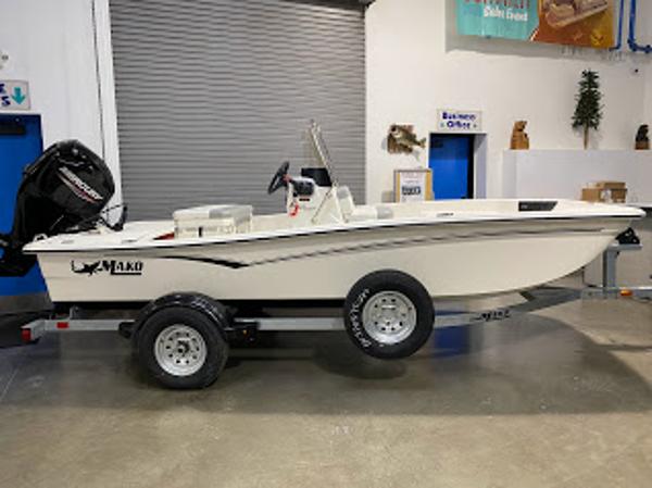 Mako Pro Skiff 15 CC 2023 Mako Pro Skiff 15 CC boat on trailer in indoor showroom.