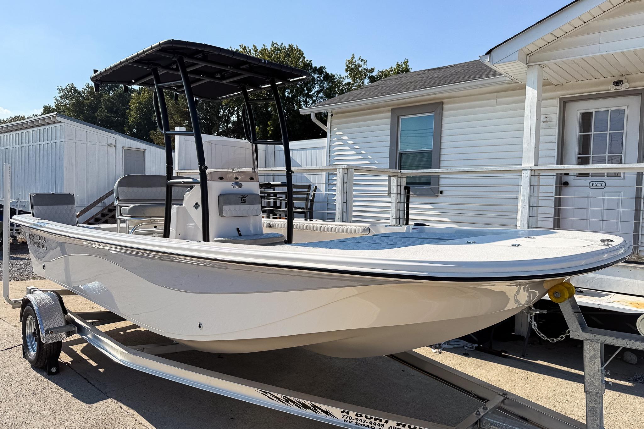 Carolina Skiff 21 LS 2025 Carolina Skiff 21 LS boat on trailer, parked near white building.