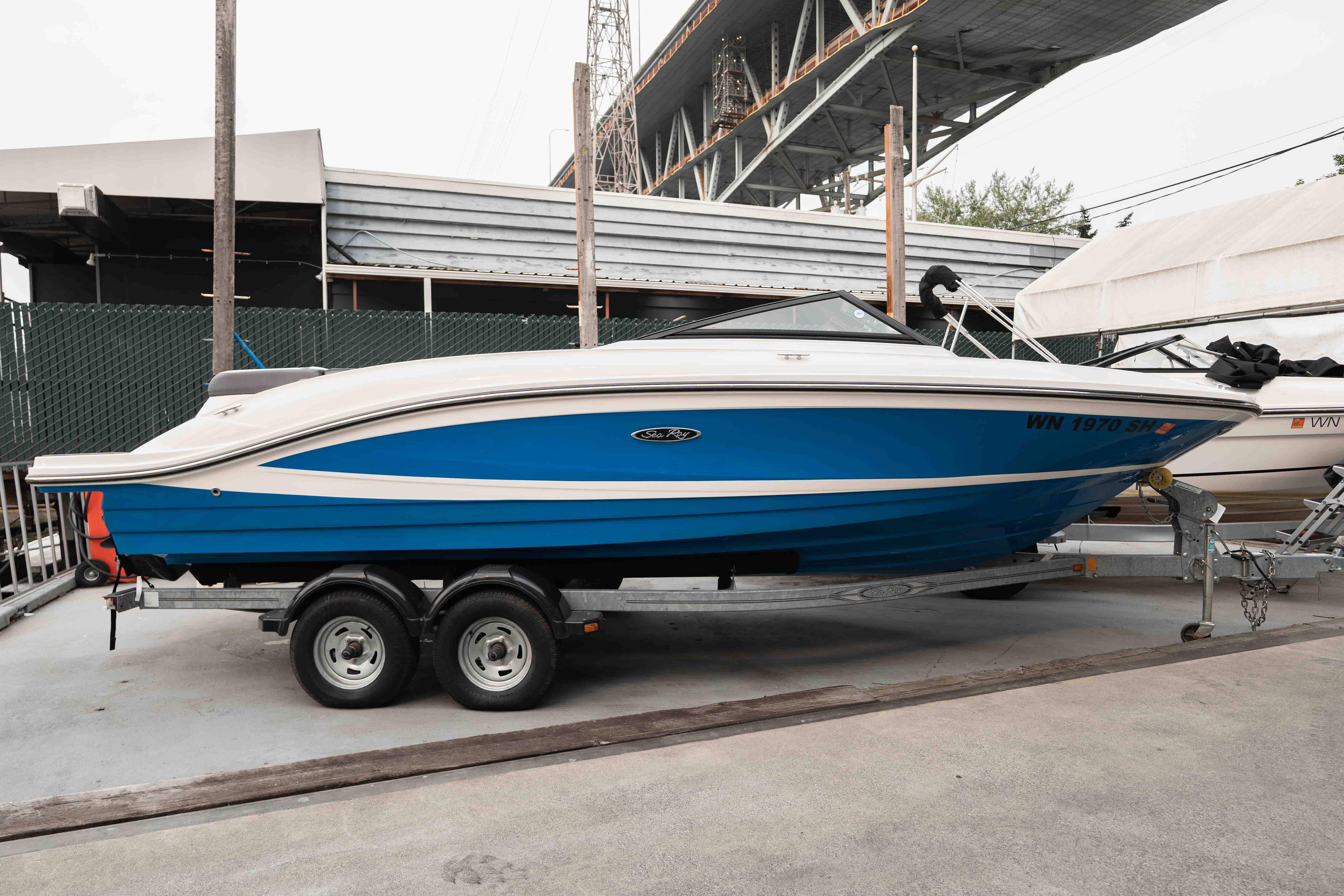 Sea Ray SPX 210 2015 Sea Ray SPX 210 boat on trailer, blue and white design, parked outdoors.