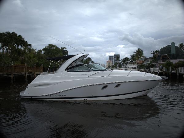 Rinker 320 Express Cruiser 2017 Rinker 320 Express Cruiser on a calm waterway, surrounded by lush greenery.