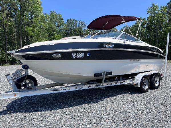 Stingray 215LR 2013 Stingray 215LR boat on trailer, parked outdoors.