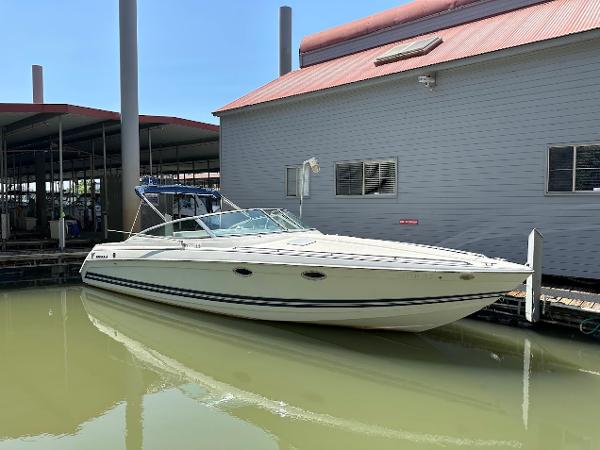 Formula 330 SS 2000 Formula 330 SS boat docked beside a building, under clear blue sky.