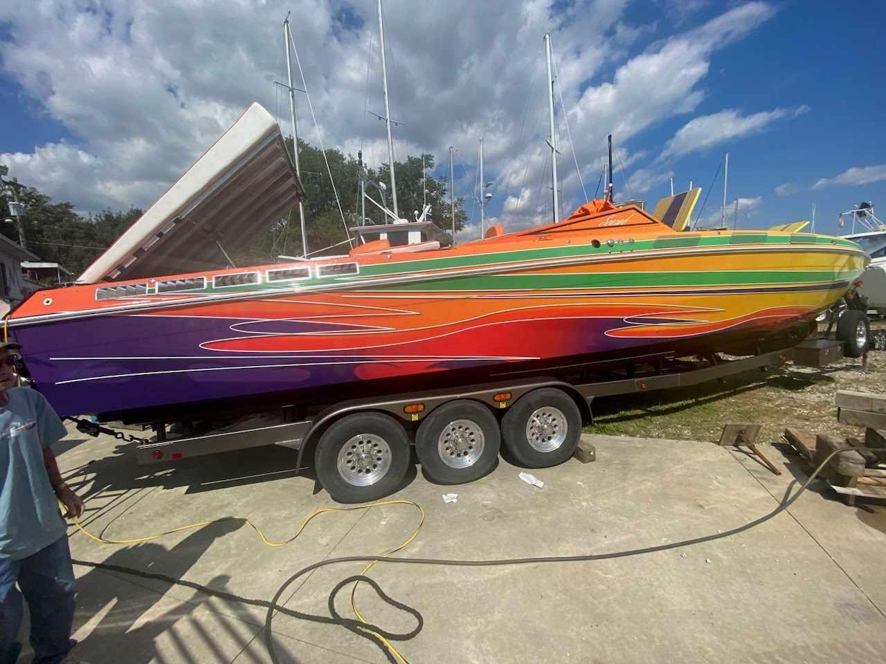 Wellcraft Scrab Colorful 1979 Wellcraft Scrab boat on trailer under a partly cloudy sky.