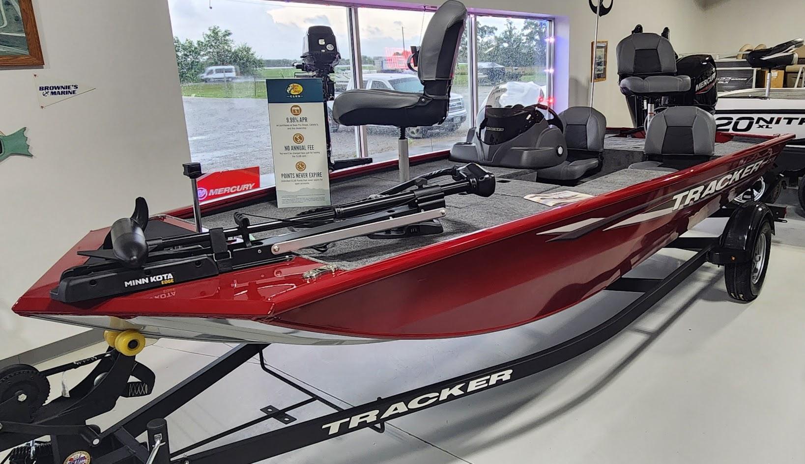 Tracker Pro 170 2025 Tracker Pro 170 boat in showroom, red exterior, equipped with Minn Kota motor.