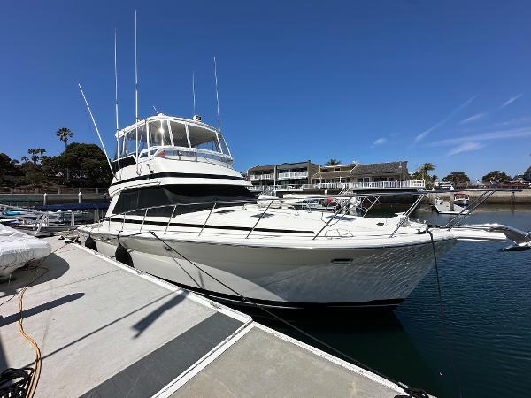 Riviera 43 Open Flybridge 1998 Riviera 43 Open Flybridge yacht docked in a marina under clear blue skies.