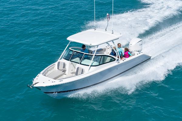 Pursuit DC 246 Dual Console 2025 Pursuit DC 246 boat cruising on clear blue water.