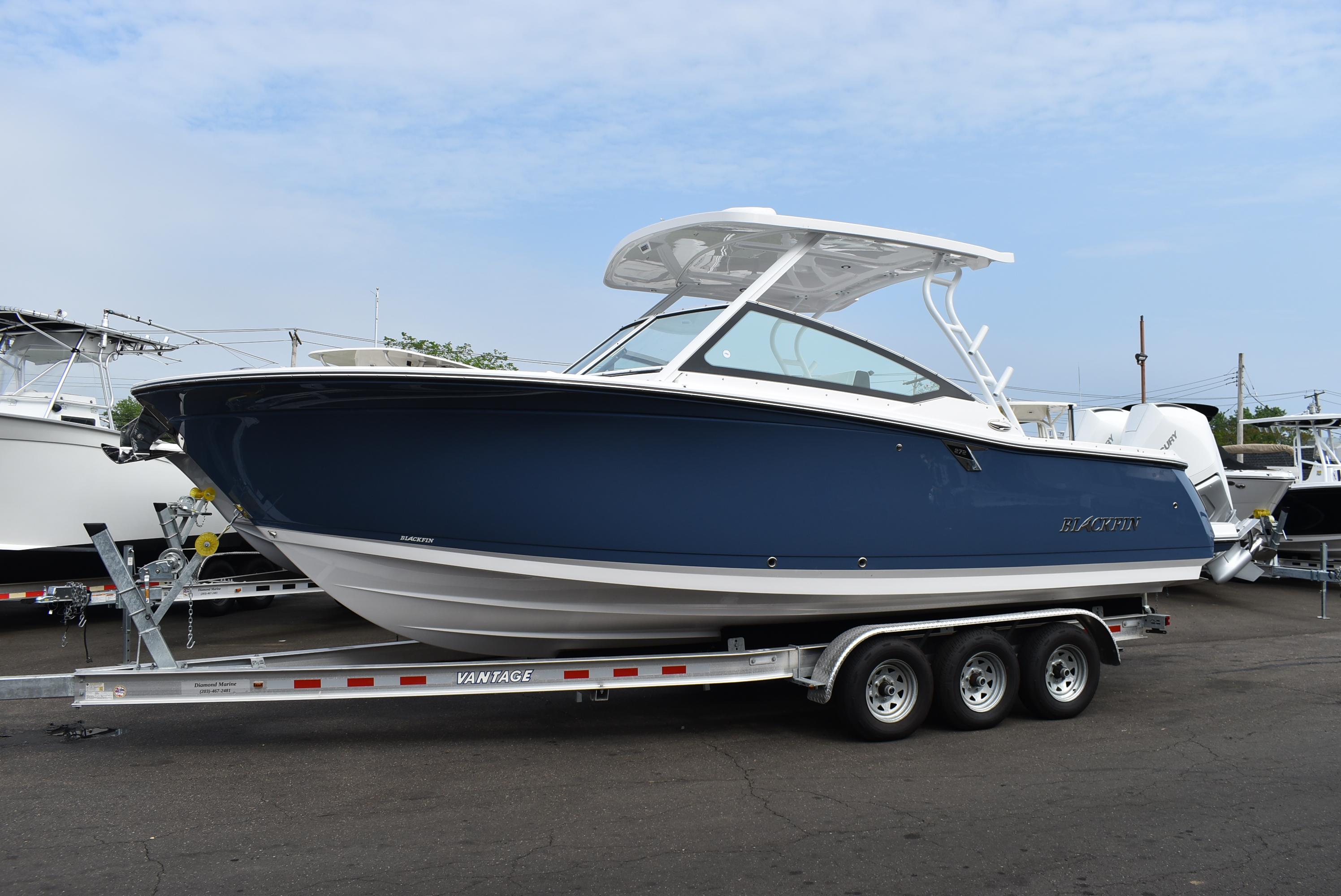 Blackfin 272 DC 2025 Blackfin 272 DC boat on trailer, blue hull, parked outdoors.