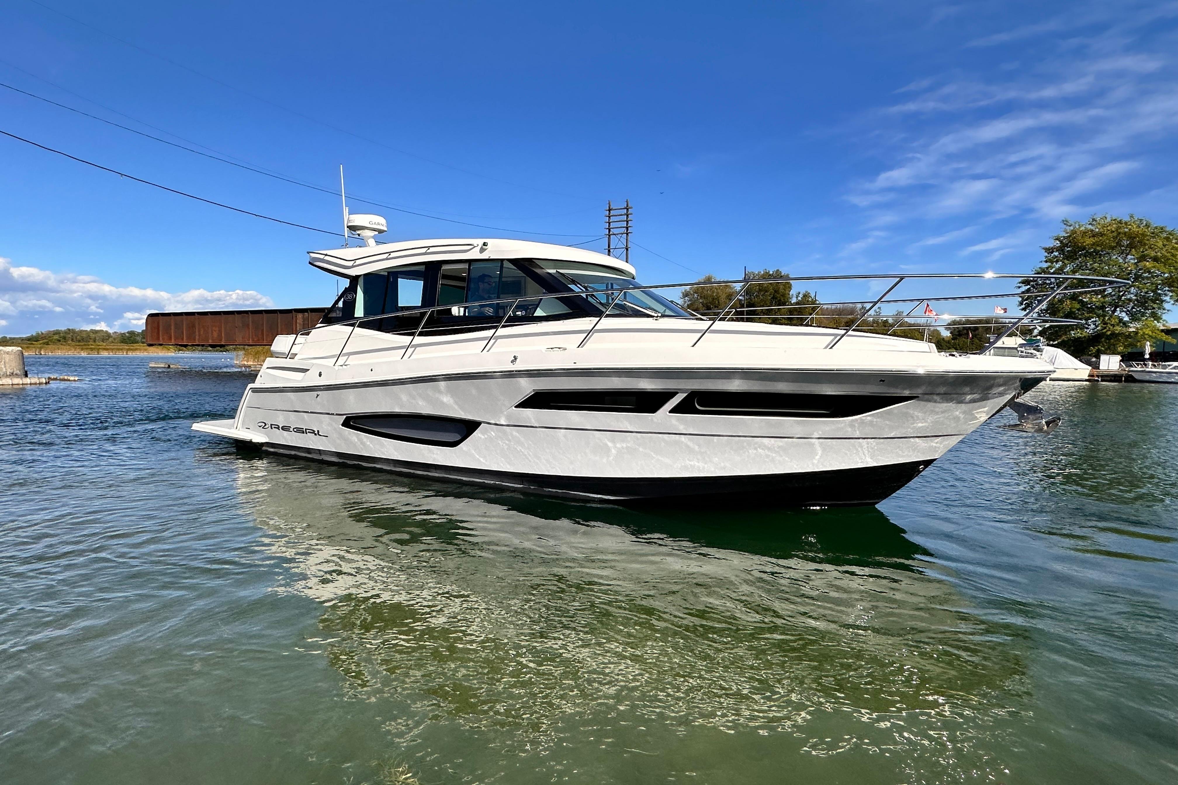 Regal 38 Grande Coupe 2024 Regal 38 Grande Coupe yacht on calm water under clear blue sky.
