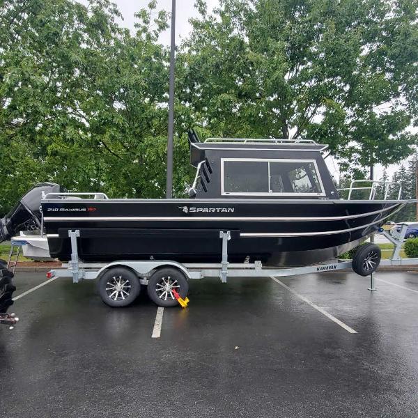 Spartan Maximus 240 2024 Spartan Maximus 240 boat on a trailer in a parking lot.