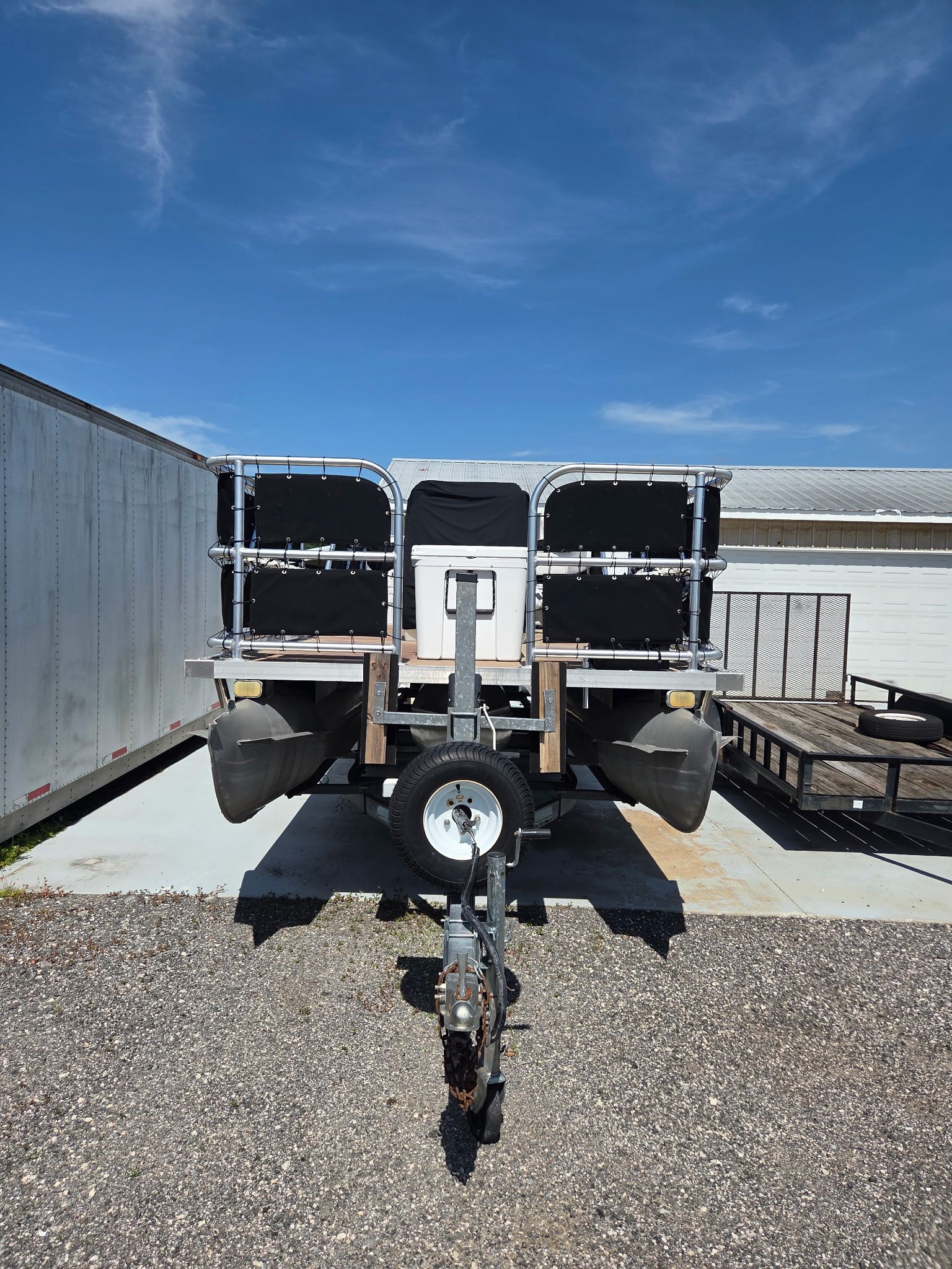 Custom Bass Tritoon 2020 Custom Bass Tritoon on trailer under clear blue sky.