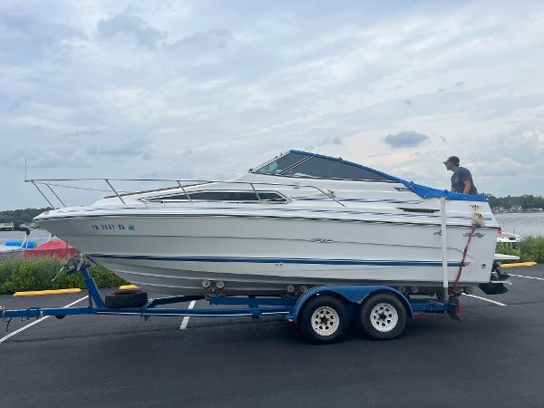 Sea Ray 230 Weekender 1989 Sea Ray 230 Weekender boat on a trailer in a parking lot.
