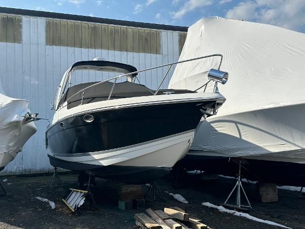 Formula 27 PC 2007 Formula 27 PC boat in storage, black and white hull, covered boats nearby.