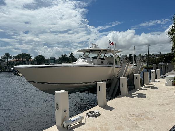 Pursuit 408S Pursuit 408S 2018 boat docked by waterfront under cloudy sky.