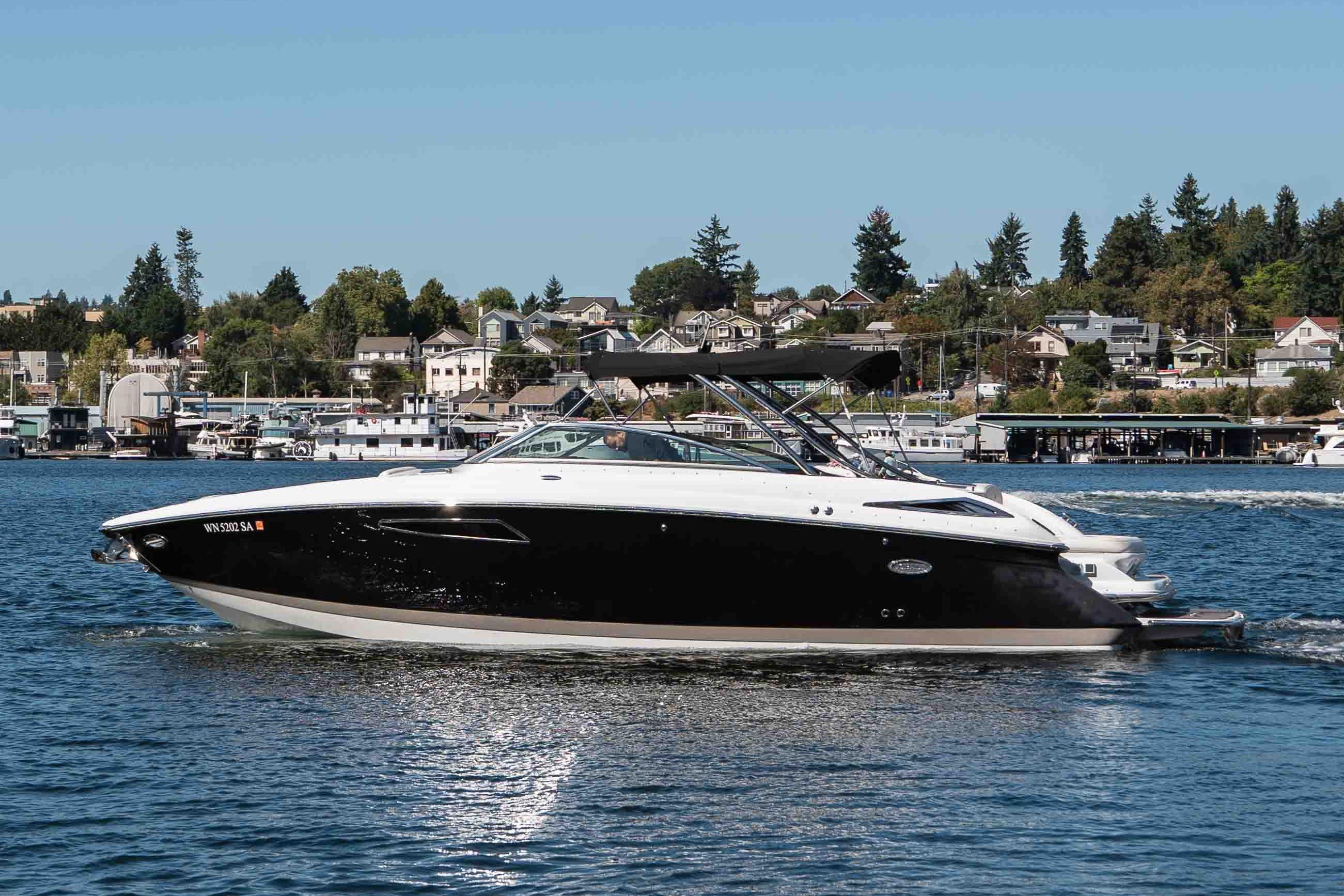 Cobalt 336 2013 Cobalt 336 boat cruising on a scenic lake with houses in the background.