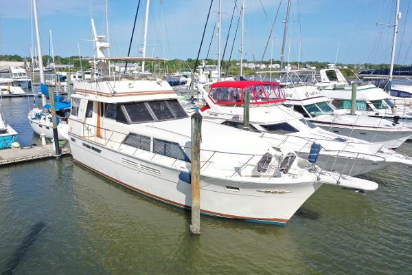 Chris-Craft Constellation 460 1985 Chris-Craft 460 Constellation yacht docked at marina, surrounded by other boats.