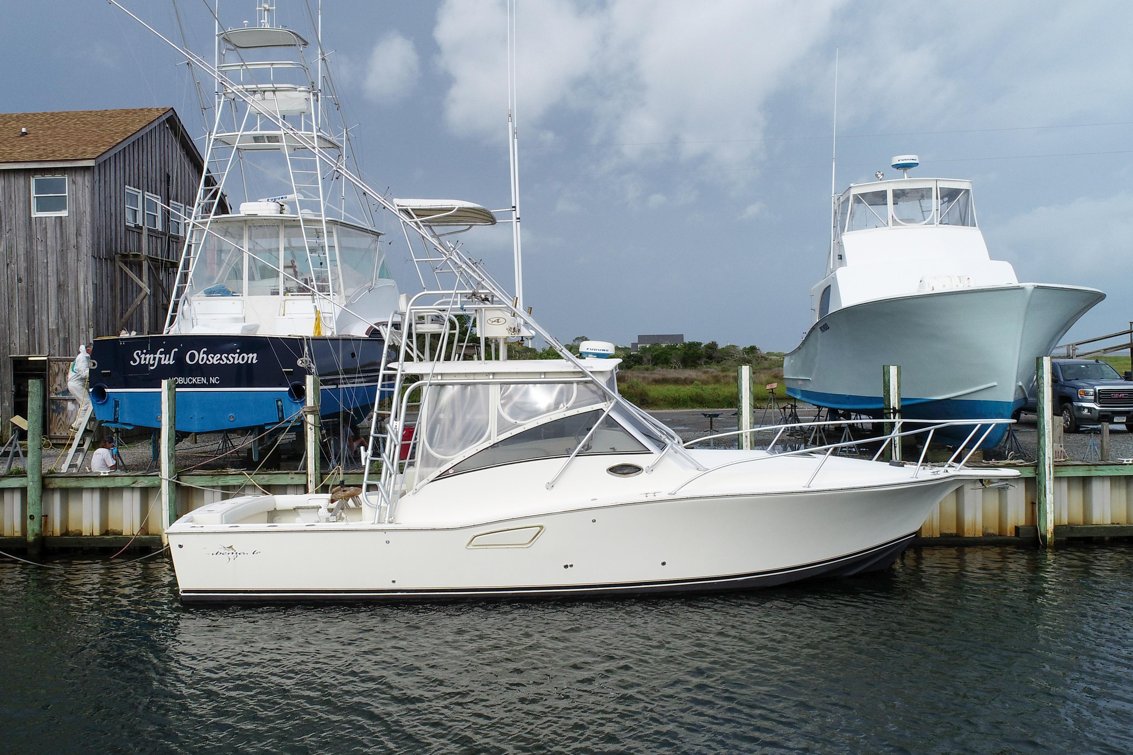 Albemarle 320 Express 2003 Albemarle 320 Express boat docked at a marina with other boats.