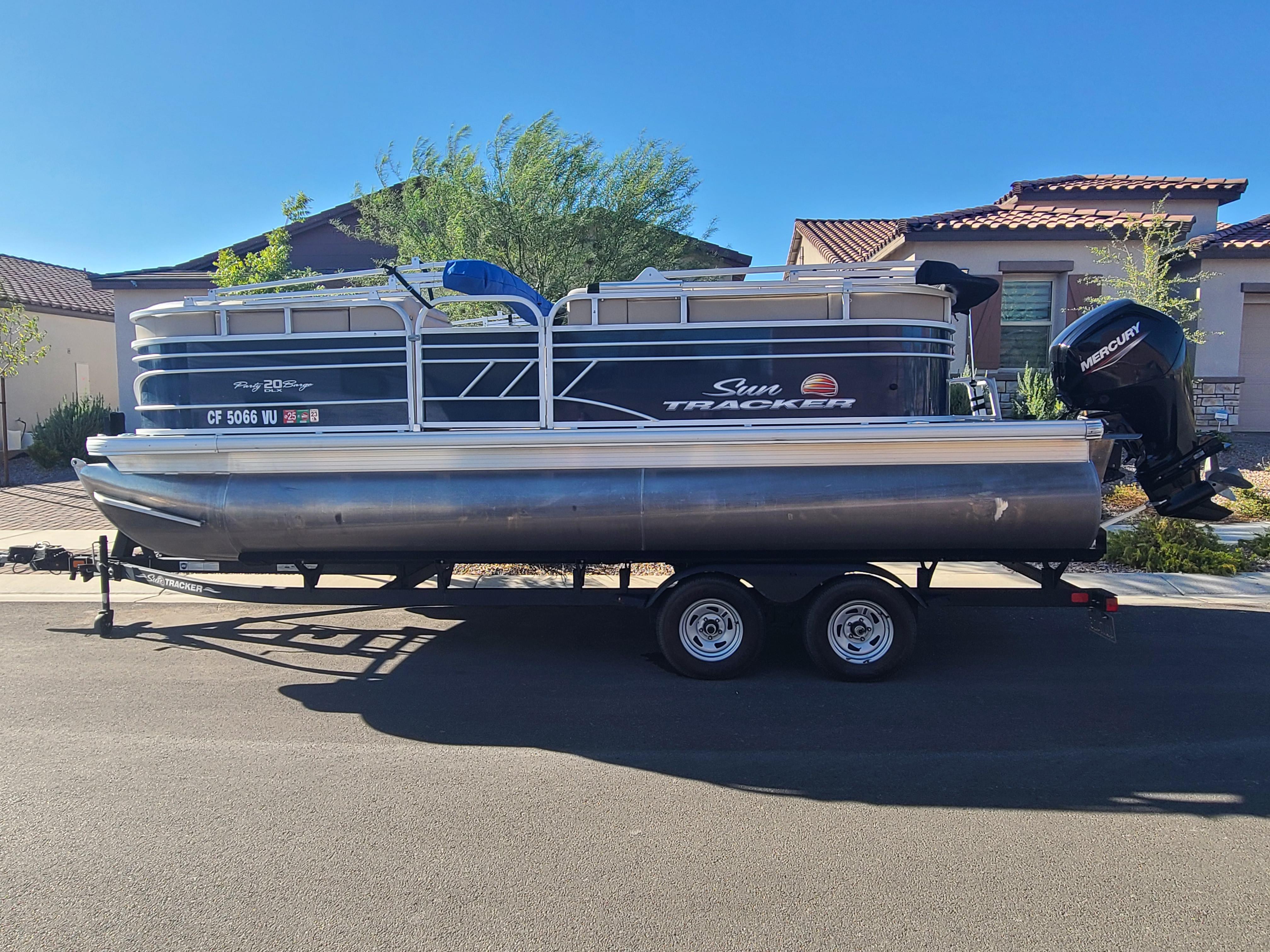 Sun Tracker Party Barge 20 DLX 2022 Sun Tracker Party Barge 20 DLX pontoon boat on trailer, parked in residential area.