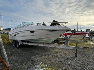Chaparral 245 SSi Chaparral 245 SSi 2000 boat on trailer, labeled "Seas the Day," parked outdoors.