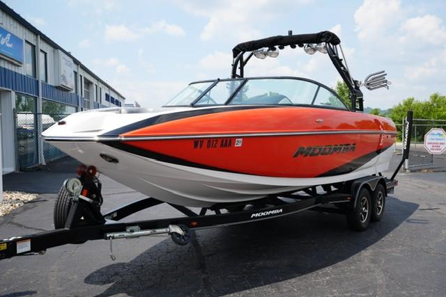 Moomba Mojo 2016 Moomba Mojo boat in vibrant orange on a trailer, parked outdoors.