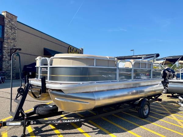 Sun Tracker Party Barge 18 DLX 2024 Sun Tracker Party Barge 18 DLX pontoon boat on trailer outside Cabela's.