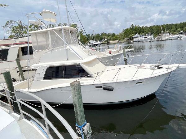 Hatteras 36 Convertible 1975 Hatteras 36 Convertible yacht docked at a marina, surrounded by calm waters.