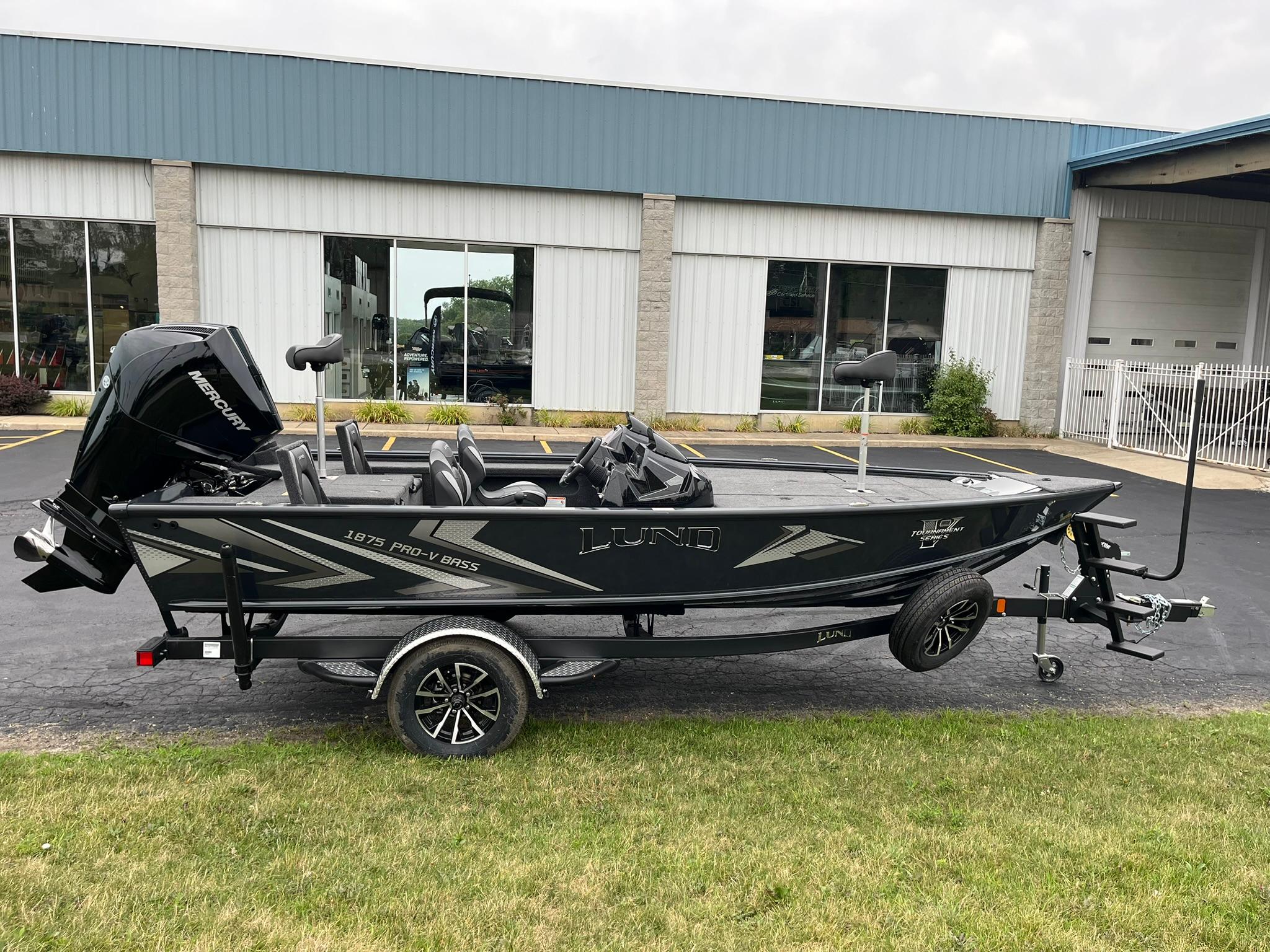 Lund 1875 Pro-V Bass XS 2026 Lund 1875 Pro-V Bass XS boat on trailer, parked outside a building.