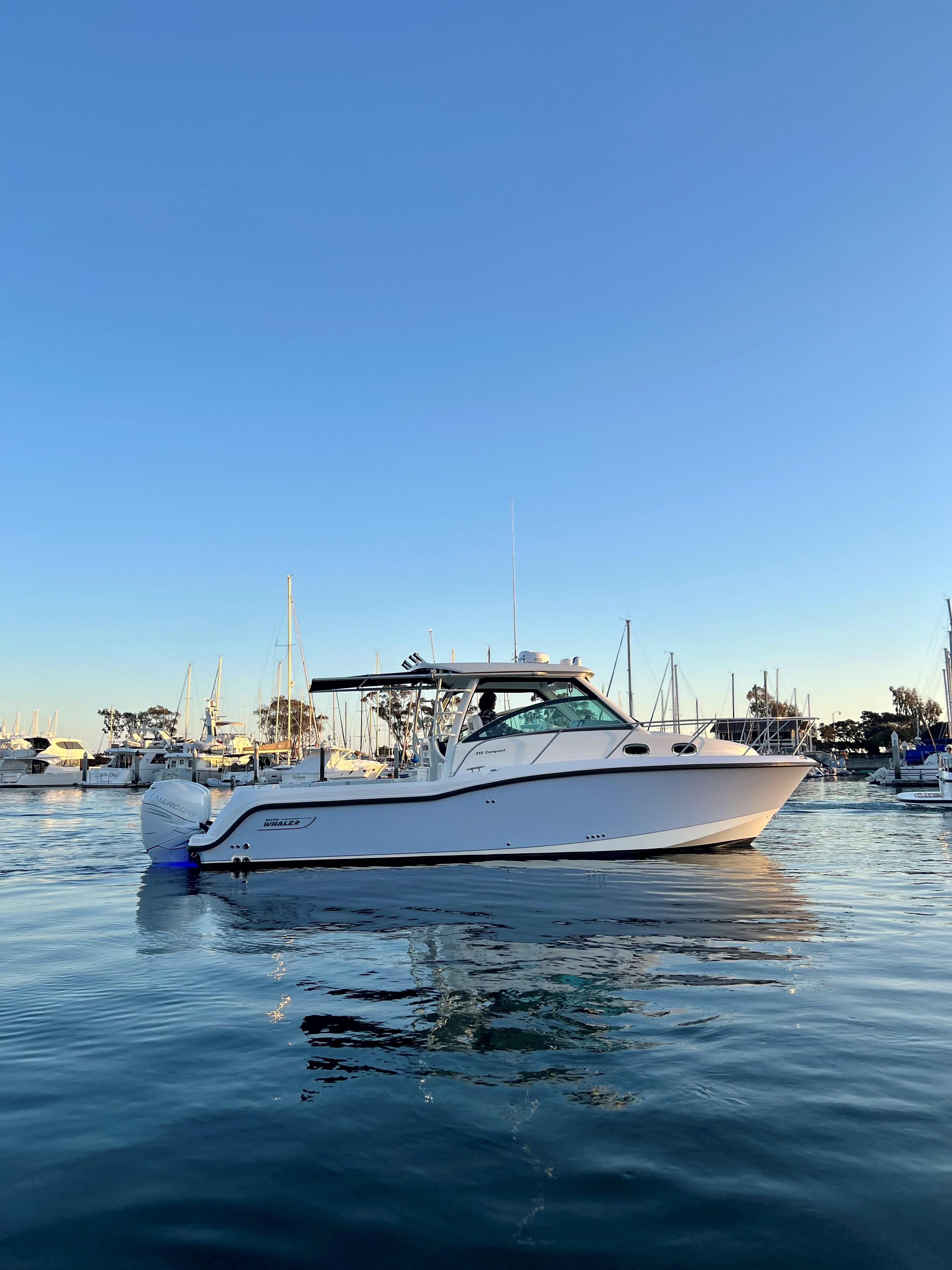 Boston Whaler 315 Conquest 2014 Boston Whaler 315 Conquest boat on calm water at sunset.