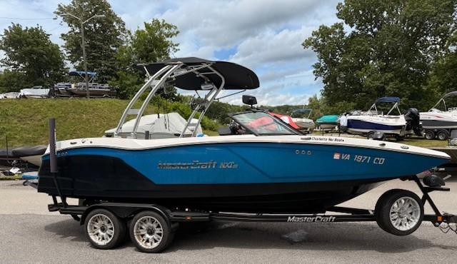 MasterCraft NXT22 2017 MasterCraft NXT22 boat on trailer, blue and white design, parked outdoors.