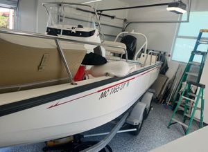 Boston Whaler MONTUCK 2022 Boston Whaler MONTUCK boat in garage, on trailer, with fishing gear and ladder nearby.