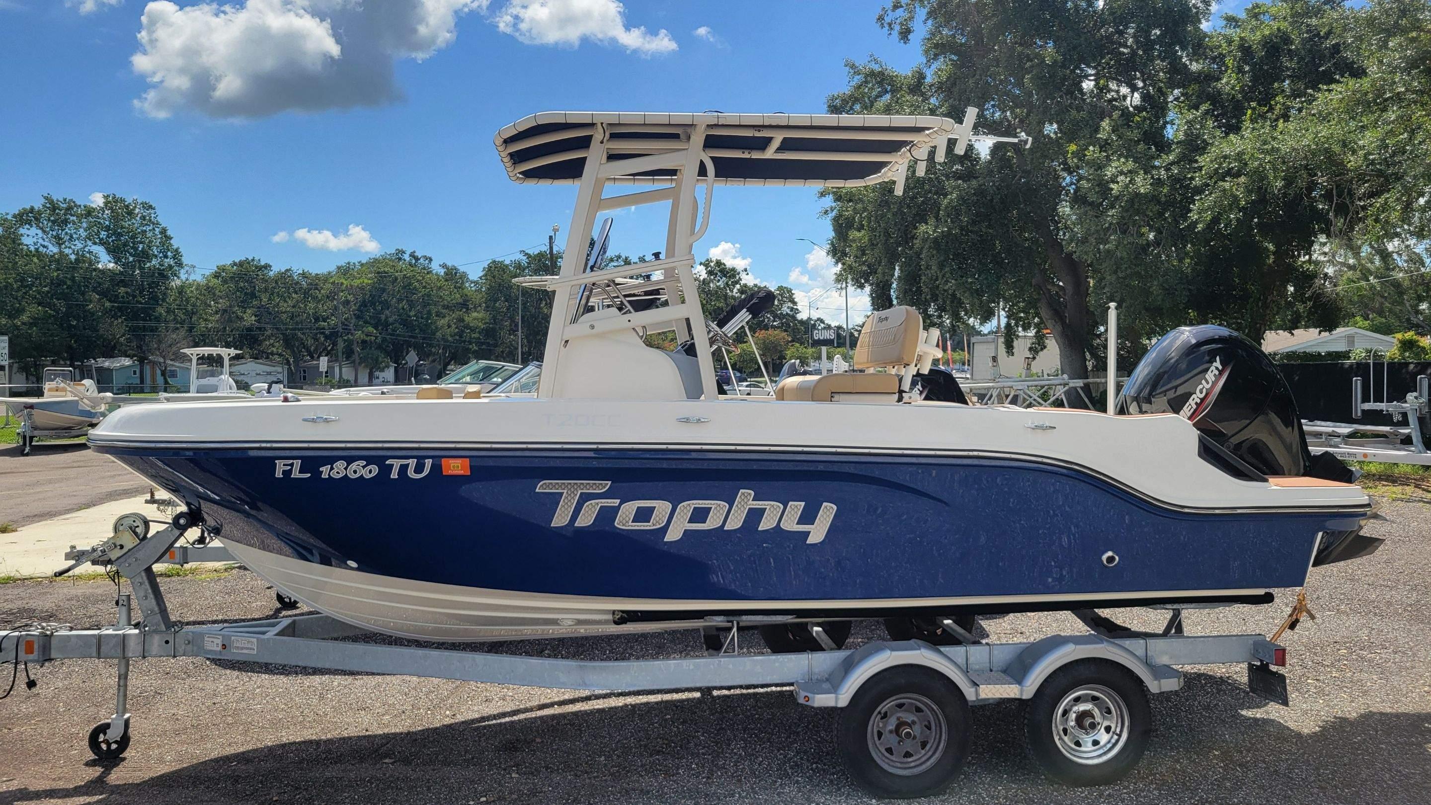 Trophy t20cc 2024 Trophy T20CC boat on trailer, blue and white design, parked outdoors under clear sky.