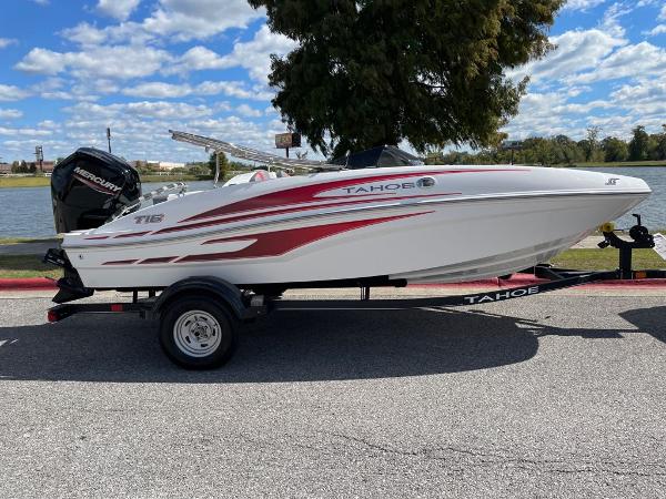 Tahoe T16 2024 Tahoe T16 boat with red and white design on a trailer by a lake.