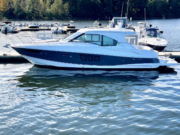 Cruisers Yachts 45 Cantius 2018 Cruisers 45 Cantius yacht docked on a serene lake with surrounding boats.