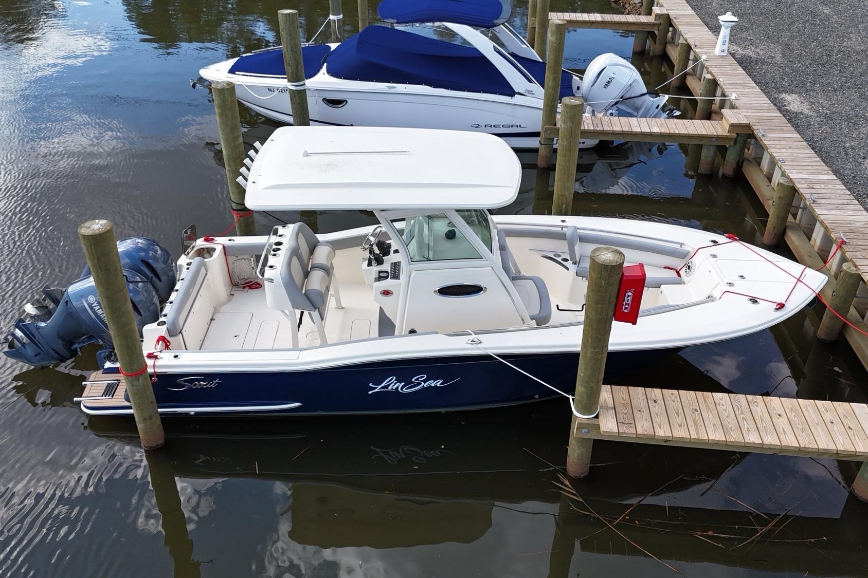 Scout 255 LXF 2020 Scout 255 LXF boat docked, featuring sleek design and Yamaha outboard engine.