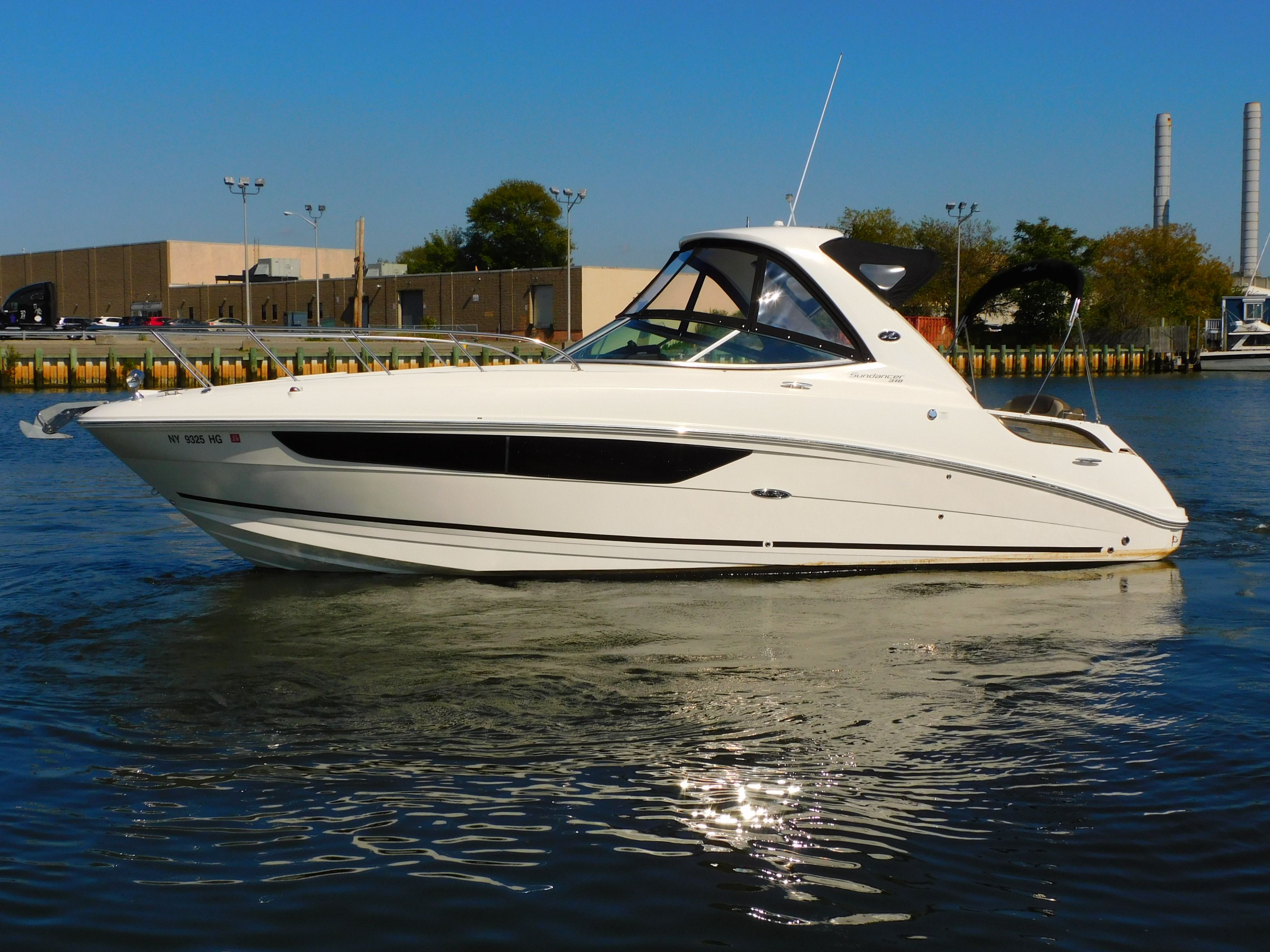 Sea Ray 310 Sundancer 2015 Sea Ray 310 Sundancer boat on calm water, dockside view.