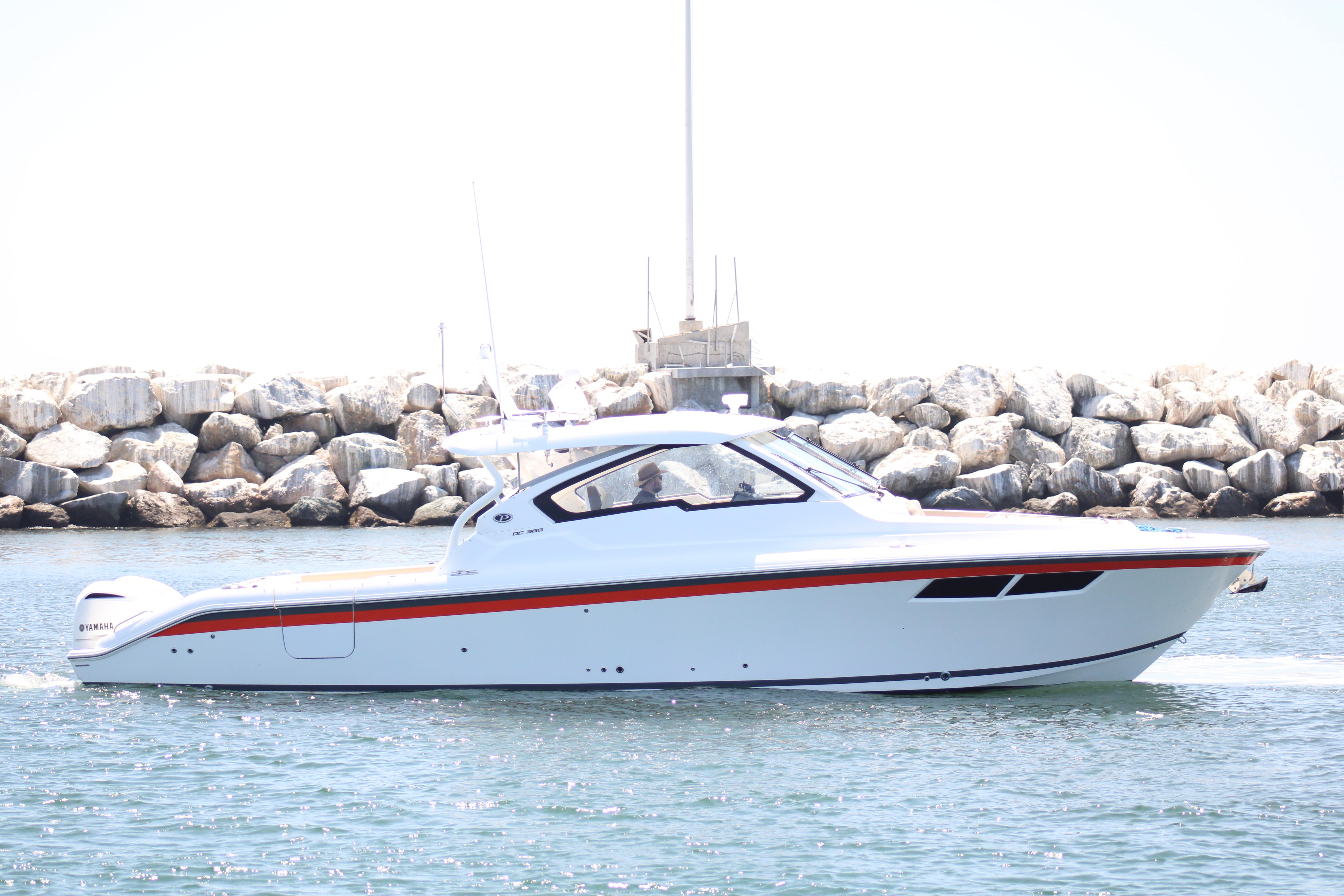 Pursuit DC 365 Dual Console 2019 Pursuit DC 365 Dual Console boat cruising near rocky shoreline.