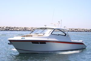 Pursuit DC 365 Dual Console 2019 Pursuit DC 365 Dual Console boat cruising on water near rocky shoreline.