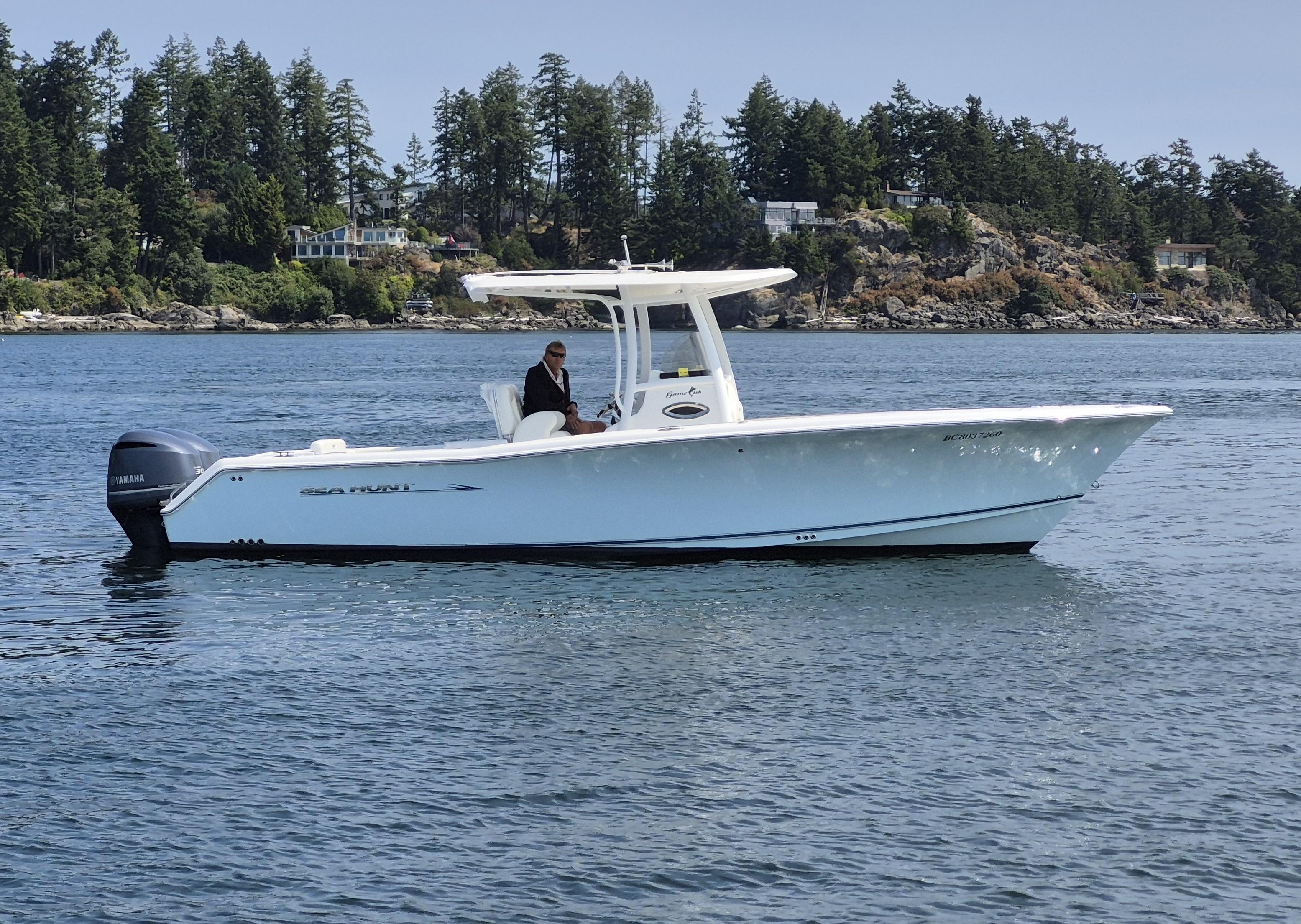 Sea Hunt Gamefish 29 2013 Sea Hunt Gamefish 29 boat on calm water with scenic forested background.