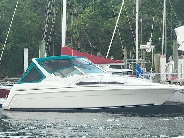 Carver 360 Mid -Cabin Express 1996 Carver 360 Mid-Cabin Express boat docked in a marina with green canopy.