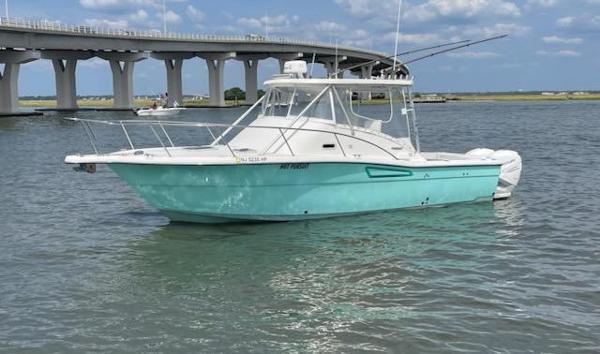 Pursuit 3000 Offshore 1999 Pursuit 3000 Offshore boat on water near a bridge, clear sky.